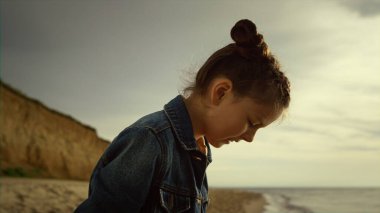 Deniz kıyısında yürüyen bir çocuk. Sakin çocuk okyanus kıyısında tatilin tadını çıkarıyor..