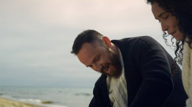 Deniz kıyısı tatilinde eğlenen heyecanlı çift. İnsanlar dışarıda gülüyor.