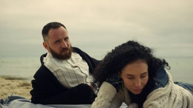 Plajda kameraya bakan Latin bir çift. Sevgilisi dışarıda dinleniyor..