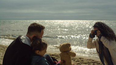 Aile grubu, Sunlight Sea Beach 'te fotoğraf çekiyor. İnsanlar doğayı sever.