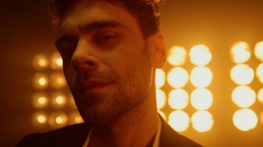 Kulüp ışıklarında baştan çıkarıcı görünen bir adam. Erkeksi modelin portresi