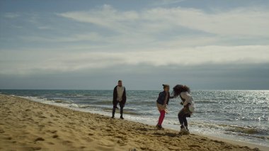 Deniz kıyısından atlayan insanlar. Neşeli aile deniz kenarında iyi tatiller..
