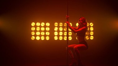 Striptiz kulübünde erotik dans gösteren seksi sarışın. Poledans eden seksi kadın..
