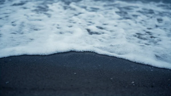 Espuma do mar quebrando areia da praia lá fora. Azul oceano ondas bater costa fundo — Fotografia de Stock