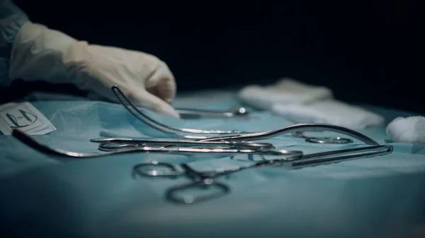 Tabela z instrumentami chirurgicznymi w ciemnej sterylnej sali operacyjnej widok z bliska — Zdjęcie stockowe
