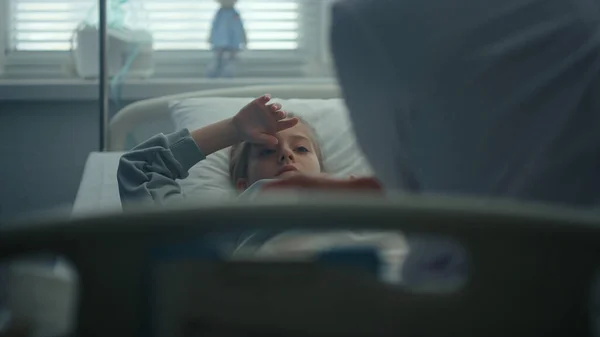 悲しい女の子嘘病院ベッド上の毎日医療検査でクリニック肖像画. — ストック写真