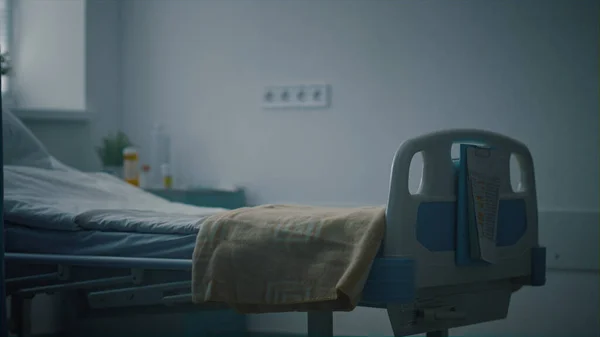 Closeup άδειο κρεβάτι νοσοκομείου με ιατρικά αρχεία που συνδέονται με μονάδα εντατικής θεραπείας. — Φωτογραφία Αρχείου