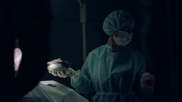 Enfermera entregando instrumentos quirúrgicos ayudando al médico en la sala de emergencias del hospital. — Foto de Stock