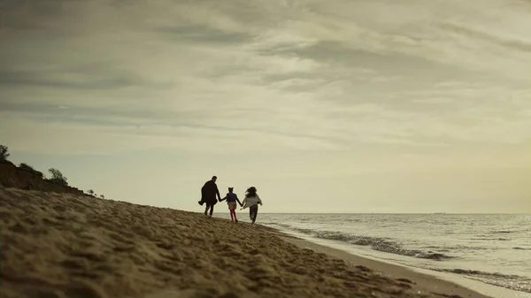 Rodzinny krajobraz plaży. Weseli ludzie spacerują razem po piaszczystym wybrzeżu morza. — Zdjęcie stockowe