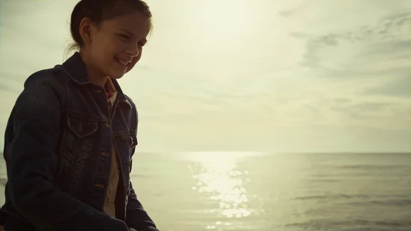 Захоплена дитина грає на пляжі на ранковому морі. Молода дівчина насолоджується відпочинком на березі . — стокове фото