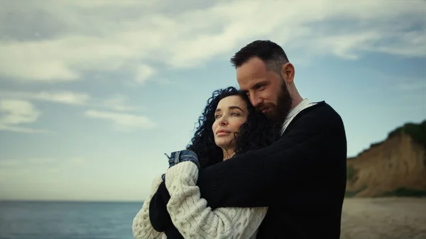 Romantic people hugging at seaside beach. Calm couple showing love on nature.