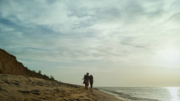 Glada människor går stranden vid havsvågor. Familjen njuta av helgen på stranden natur utsikt — Stockfoto