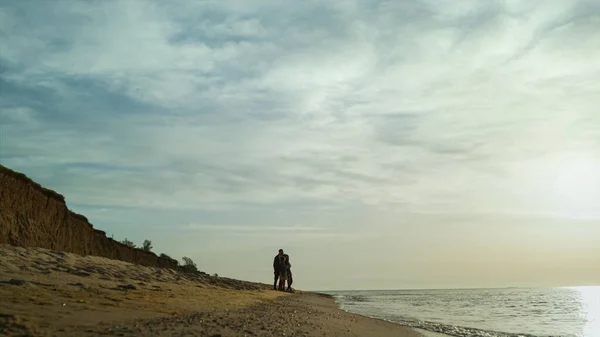 人々はビーチの風景立ってグループ。波の衝突による家族の散歩日没の海. — ストック写真