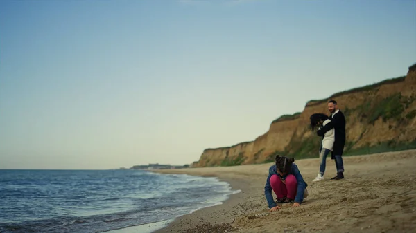 People relaxing family vacation at sea beach. Parents child enjoying coastline.