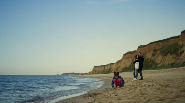 Νεαρή οικογένεια απολαμβάνουν τις διακοπές στη φύση παραλία του ωκεανού. Παιδικό παιχνίδι από τους γονείς στην ύπαιθρο — Φωτογραφία Αρχείου
