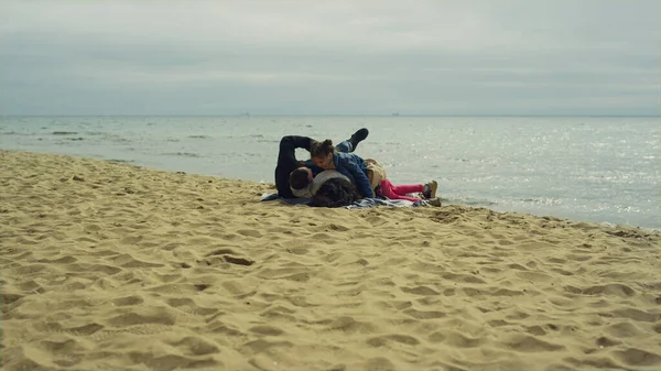 Anne ve babası sakin deniz kenarında tatilin tadını çıkarıyorlar. Aile piknikte oyun oynar..