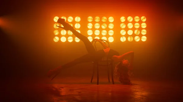 Dancer girl practicing streaptease elements on chair. Blonde dancing sexually. — Stock Photo, Image