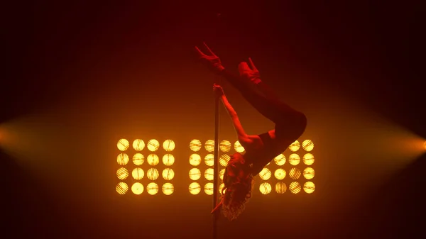 Mujer realizando trucos de poledance en focos. Rubia haciendo cordel en el pilón. — Foto de Stock