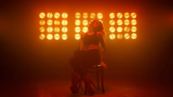 Жінка робить рухи сексуальних ніг на стільці стрип-клубу. Дівчина танцює еротичний танець — стокове фото