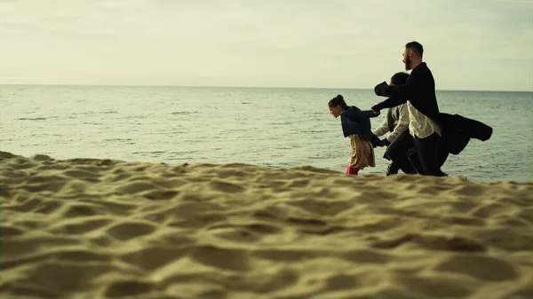 Παιχνιδιάρικη οικογενειακή παραλία με άμμο. Οι νέοι περνάνε καλά στη θάλασσα.. — Φωτογραφία Αρχείου