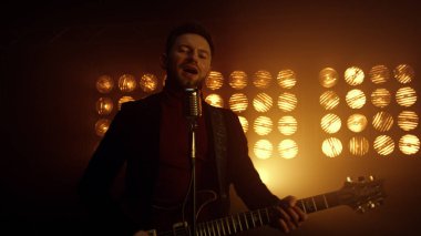 Gece kulübünde şarkı söyleyen yakışıklı bir gitarist. Gitar çalan vokalist.