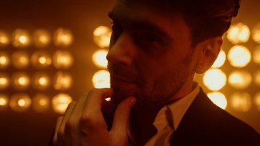 Sahnede kameraya dokunan seksi bir adam var. Olay yerinde poz veren adam.