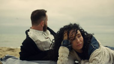 Çift plajda dinleniyor. Gençler okyanus kıyısında tatilin tadını çıkarıyor.