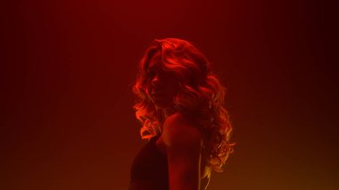 Striptiz kulübünde dans gösterisi yapan sarışın. Seksi dansçı kız el kaldırıyor.