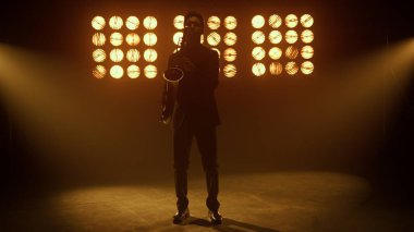 Saksafoncu sahnede tutkuyla enstrüman çalıyor. Müzisyen melodisi çalıyor