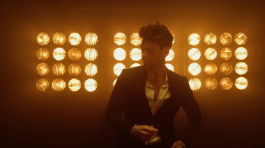 Kulüp ışıklarında düğme ilikleme ceketi giyen erkek manken. Stüdyoda poz veren adam.