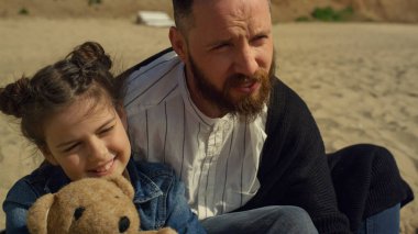 Babasının oğlu kumlu sahil denizinde birlikte vakit geçiriyor. Aile tatilde dinleniyor..