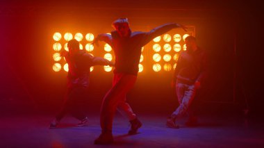 Gece kulübünde break dans yapan üç hiphop çocuğu. Dansçılar serbest dans ediyorlar..