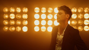 Sahne gece kulübünde yakın plan erkek modeli. Spot ışıklarında poz veren seksi adam..