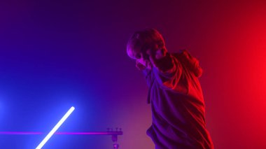 Yakışıklı dansçı, gece kulübünün neon ışıklarında break dans yapıyor..