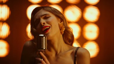 Kız şarkıcı gece kulübünde mikrofon söylüyor. Seksi bir kadın portresi.
