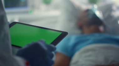 Doktor tablet kroma anahtar ekranını tutuyor. Hastanın tıbbi geçmişini kontrol ediyor.