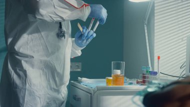 Doktor, hastane bulaşıcı ünitesinde virüs için kovid19 hastasını test ediyor..