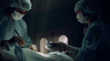 Afro-Amerikan cerrah steril hastane acil servisinde hasta ameliyat ediyor..