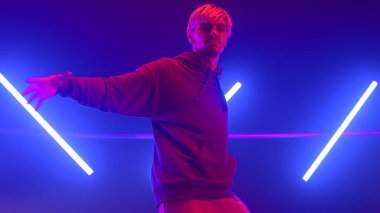 Gece kulübü ultraviyole ışıkta rahatça hareket eden etkileyici hiphop dansçısı..