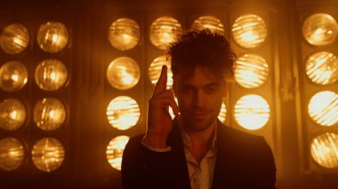 Çekici bir adam el hareketleriyle atış hareketi yapıyor. Kulüp sahnesini kapatın..