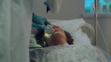 Hasta oksijen maskeli hastane yatağı soluyor. Doktor test ışığı refleksi yakın çekim