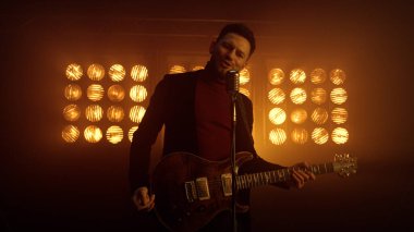 Erkek vokalist içeride müzikle dans ederek şarkı söylüyor. Gece kulübünde oynayan adam.