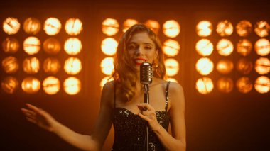 Sahnede dans eden göz kamaştırıcı kadın şarkıcı. Kız vokalist kulüpte şarkı söylüyor..