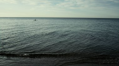 Sakin okyanus suyunun arka planında, dışarıda sakin bir doğa var. Gün batımında deniz dalgaları.