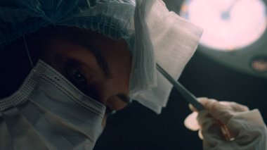 Portre cerrahı karanlık hastane yoğun bakım odasında ameliyat yapıyor.