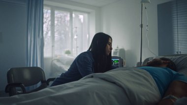 Hastanenin ziyaretçisi hastaların yüzlerini okşuyor. Modern klinik koğuşu..