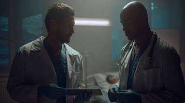 Tablet hastanesindeki hasta kayıtlarını tartışan iki doktor portresi.