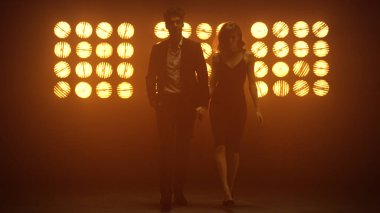 Sahnede el ele tutuşan seksi çift. Genç çift içeride poz veriyor..