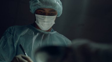 Portre Afro-Amerikan cerrah klinik odasında ameliyat yapıyor..