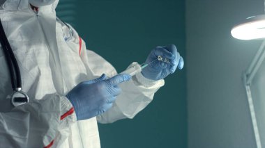 Doktor, klinik enfeksiyon bölümünde şırıngayı aşı sıvısıyla doldurdu..